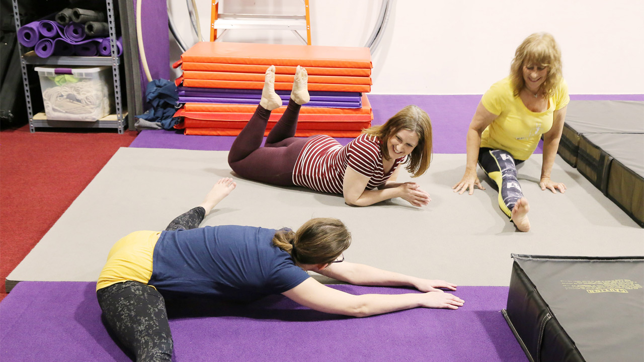Aerialists chatting while doing ground drills for aerial silks.